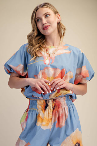 Woman wearing a blue floral dress against a beige background