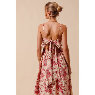 Woman wearing a floral dress with an open back on a beige background
