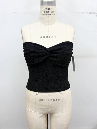 Black strapless top with a bow detail on a mannequin against a white background