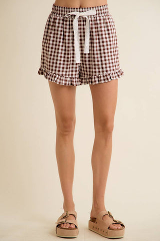 Checkered shorts worn by a person on a beige background
