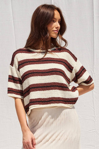 Woman wearing a striped sweater against a plain background