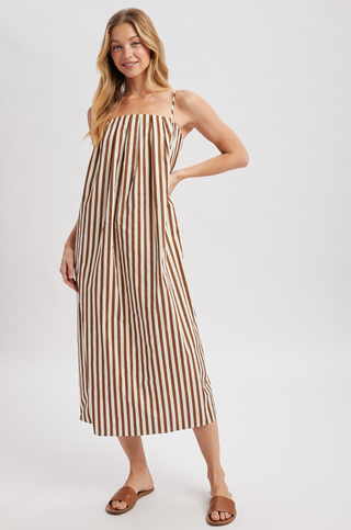 Woman wearing a brown and white striped dress on a white background