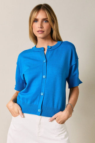 Woman wearing a blue cardigan against a beige background