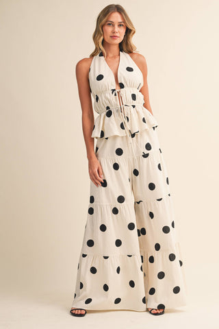 Woman wearing a polka dot dress against a beige background